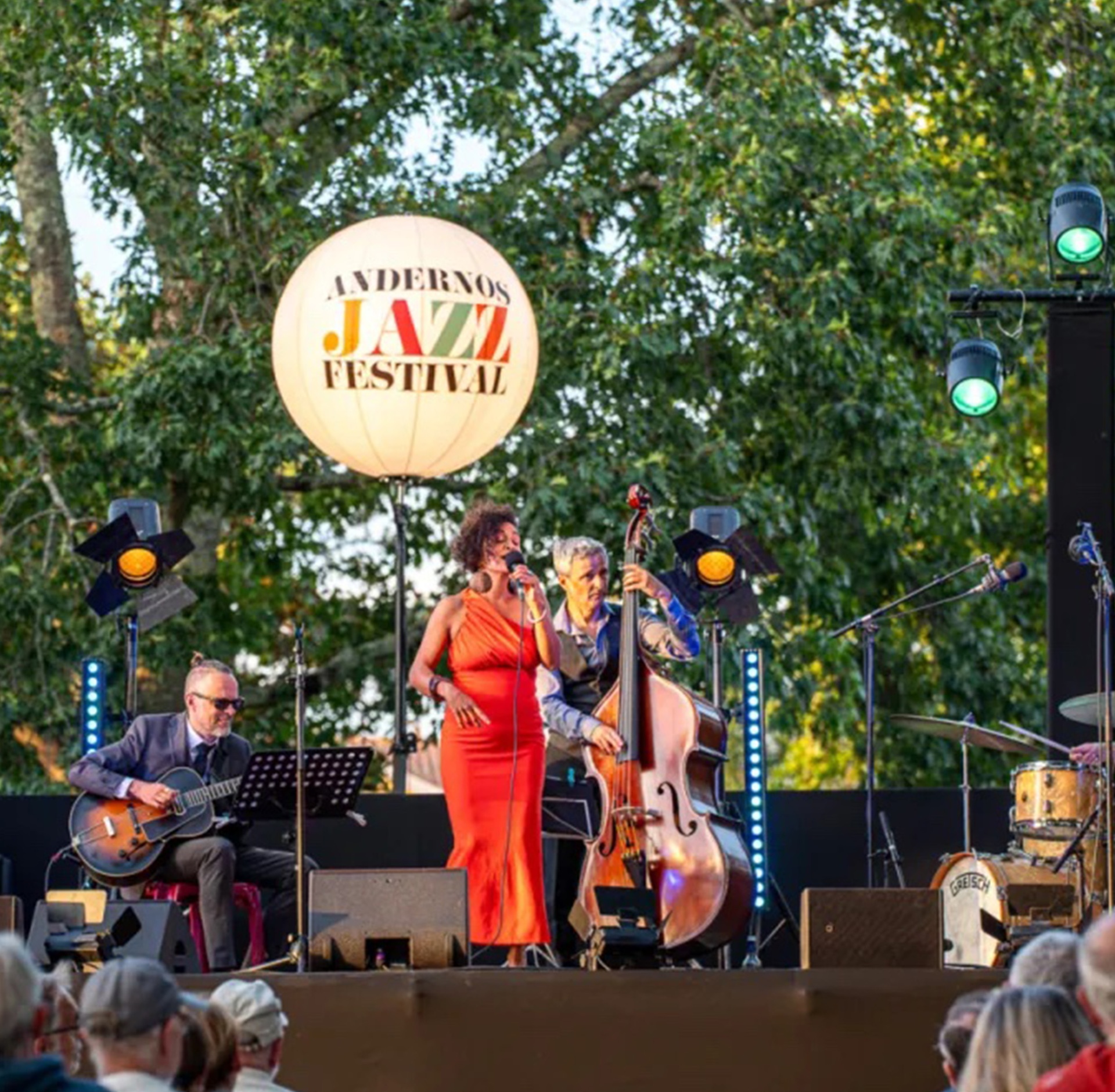 Chanteuse de jazz et son orchestre sur la scène habillée d'un ballon lumineux géant. - réalisé par Agence Kulte