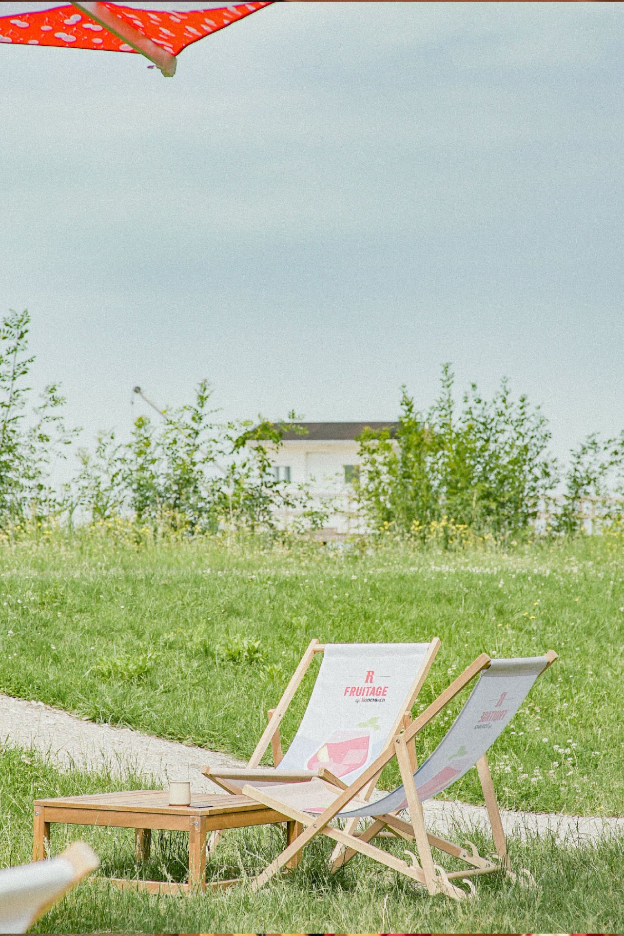 Transats et parasol Fruitage sur la pelouse de la Guinguette du Peyrat avec vue sur le paysage girondin. - réalisé par Agence Kulte