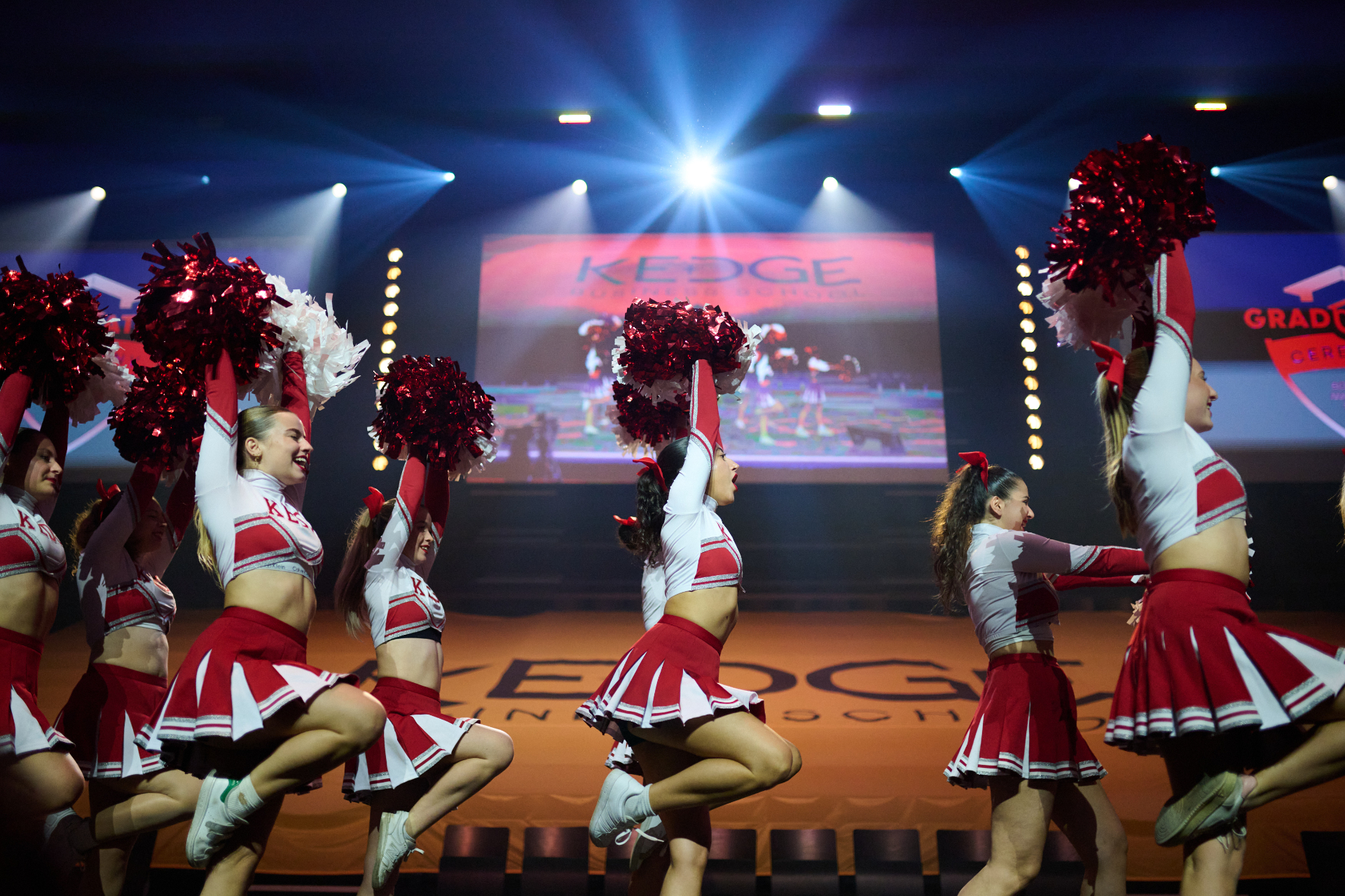 Performance de pom-pom girls sur scène lors de la cérémonie de remise des diplômes Kedge BS, magnifiant l'esprit de célébration. - réalisé par Agence Kulte